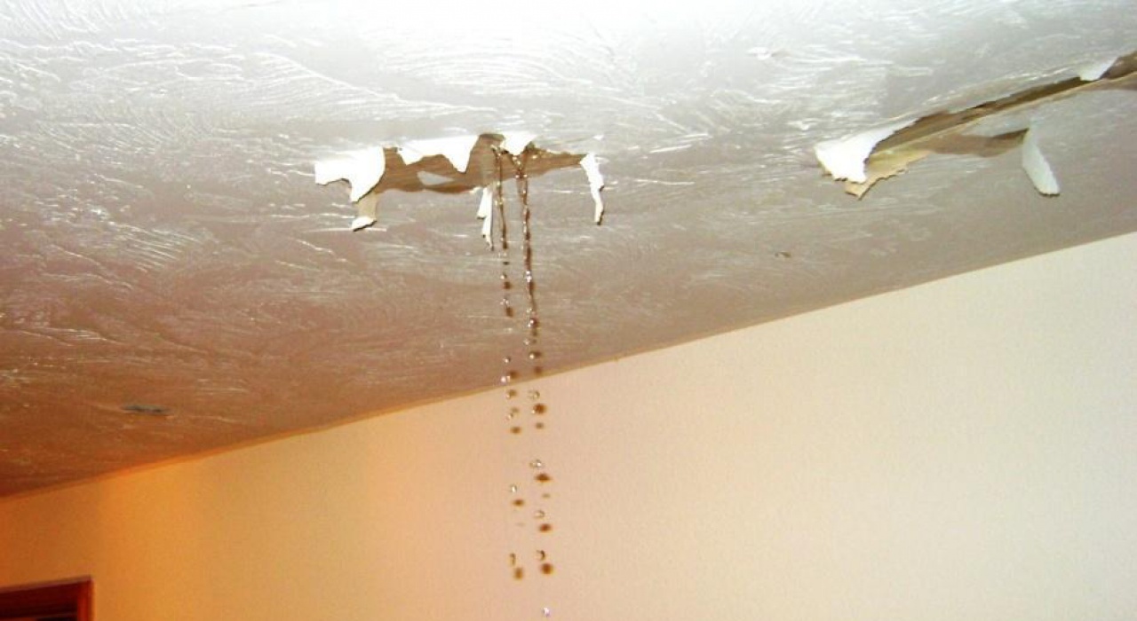 В стене капает вода. Мокрый потолок. Протечка потолка. Затопило квартиру. Натяжной потолок после затопления.